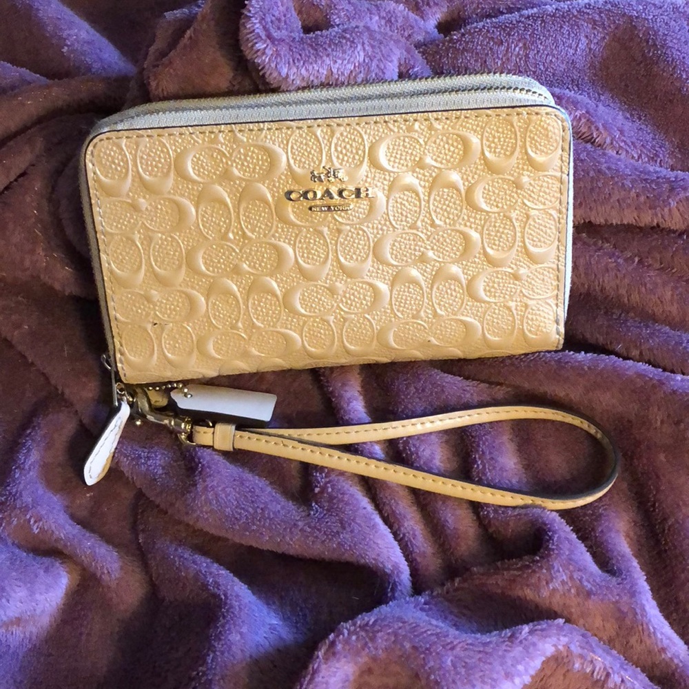 Coach signature embossed double zippered wallet.